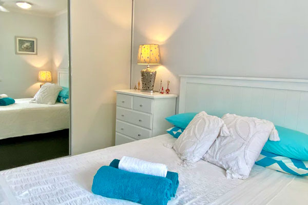 Helles Schlafzimmer mit Doppelbett und frischen Handtüchern. Bild von WordPress